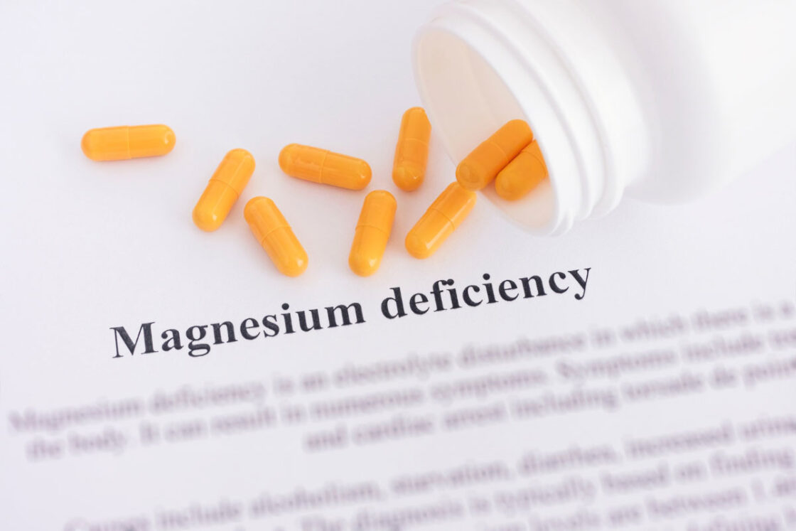 Χαρτί με τον τίτλο "Magnesium deficiency" και δισκία μαγνησίου τοποθετημένα πάνω του